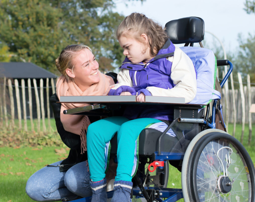 Disability a disabled child in a wheelchair relaxing outside